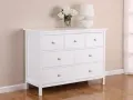 Commode blanche 3 tiroirs, prête à être relookée. Un vase de fleurs et une lampe complètent la scène.