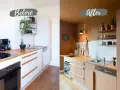 Avant/après : cuisine modernisée. Les meubles de cuisine blancs ont été repeints en taupe, transformant l'espace.