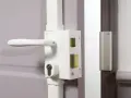 Poignée et serrure blanche avec barillet visible, prête à être verrouillée. Une clé de chaque côté assure la sécurité.
