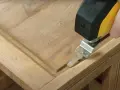 Outil oscillant utilisé pour comment poncer un meuble avec des moulures, atteignant les recoins difficiles.