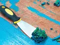 Spatule raclant de la peinture acrylique verte sur une surface en bois bleue écaillée.