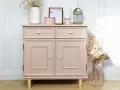 Meuble vintage repeint en rose poudré, prêt à peindre sur ancienne peinture bois. Décoré de fleurs séchées et d'une cage décorative.