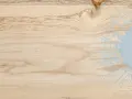 Nuancier saturateur bois : un fond de bois clair avec des motifs abstraits bleus rappelant des éclaboussures et des cercles.