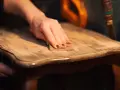 Main poncée pour enlever vernis bois. Le bicarbonate de soude peut aider à décaper.