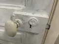 Poignée de porte ancienne et serrure en cours de préparation pour décaper une porte en bois peinte.