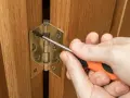 Réglage d'une charnière de porte de placard en bois avec un tournevis. Quelle charnière pour porte placard choisir ?