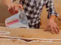Application d'une résine transparente sur un meuble bois gonflé par l'eau, pour le restaurer et le protéger.