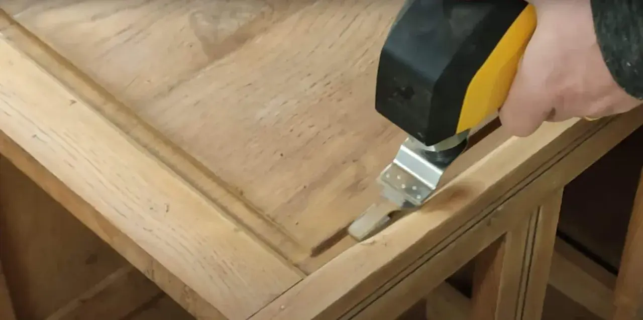 Outil oscillant utilisé pour comment poncer un meuble avec des moulures, atteignant les recoins difficiles.