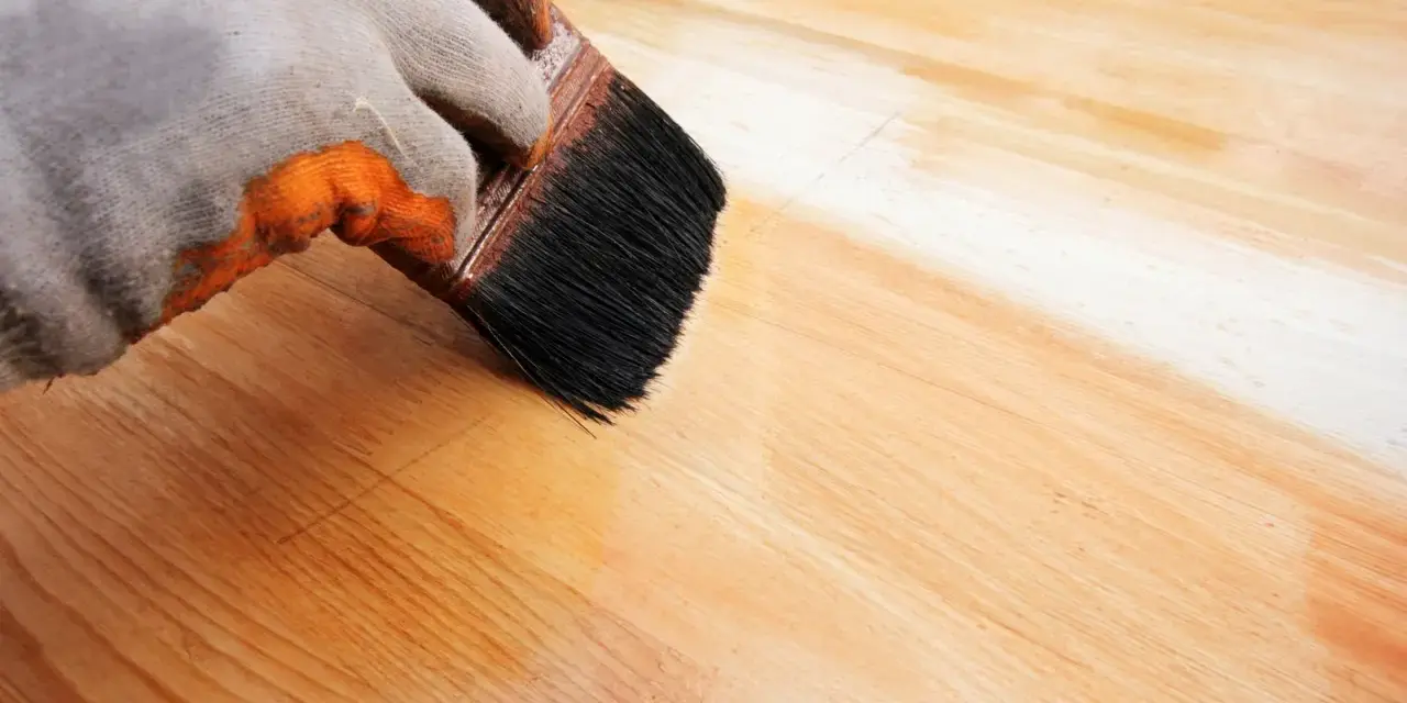 Application d'un vernis protecteur pour le traitement plan de travail bois. La brosse dépose une couche uniforme sur le bois clair.