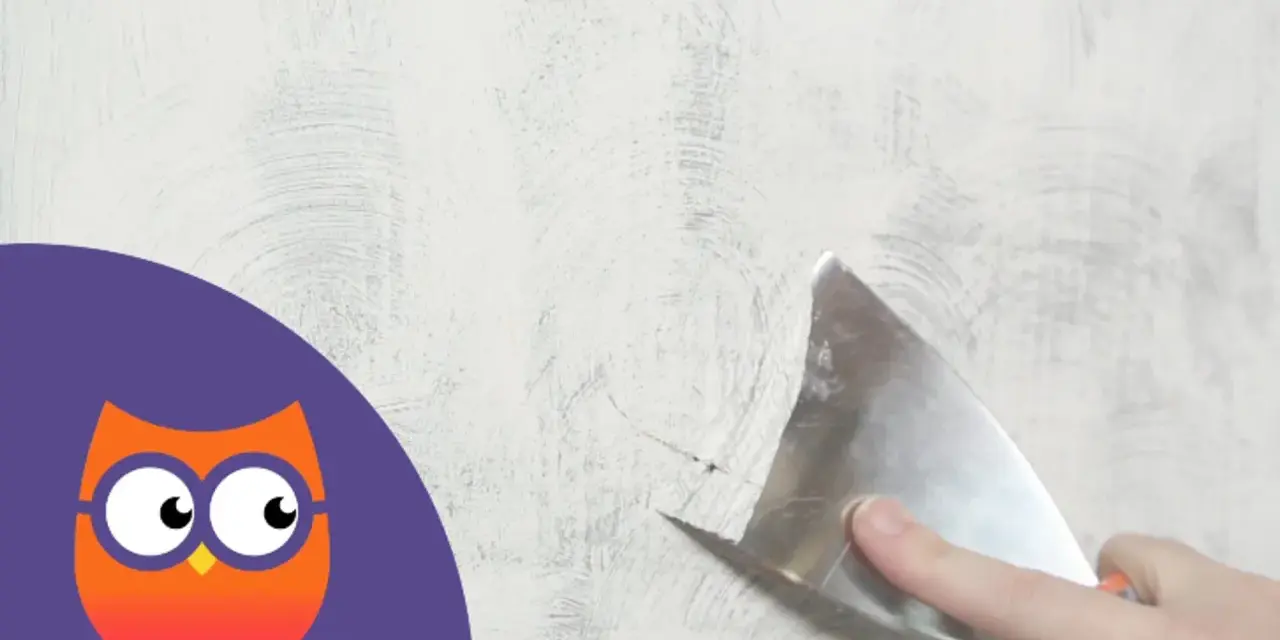 Maintenant, il faut enlever la peinture d'un mur avec une spatule. Un hibou curieux observe.
