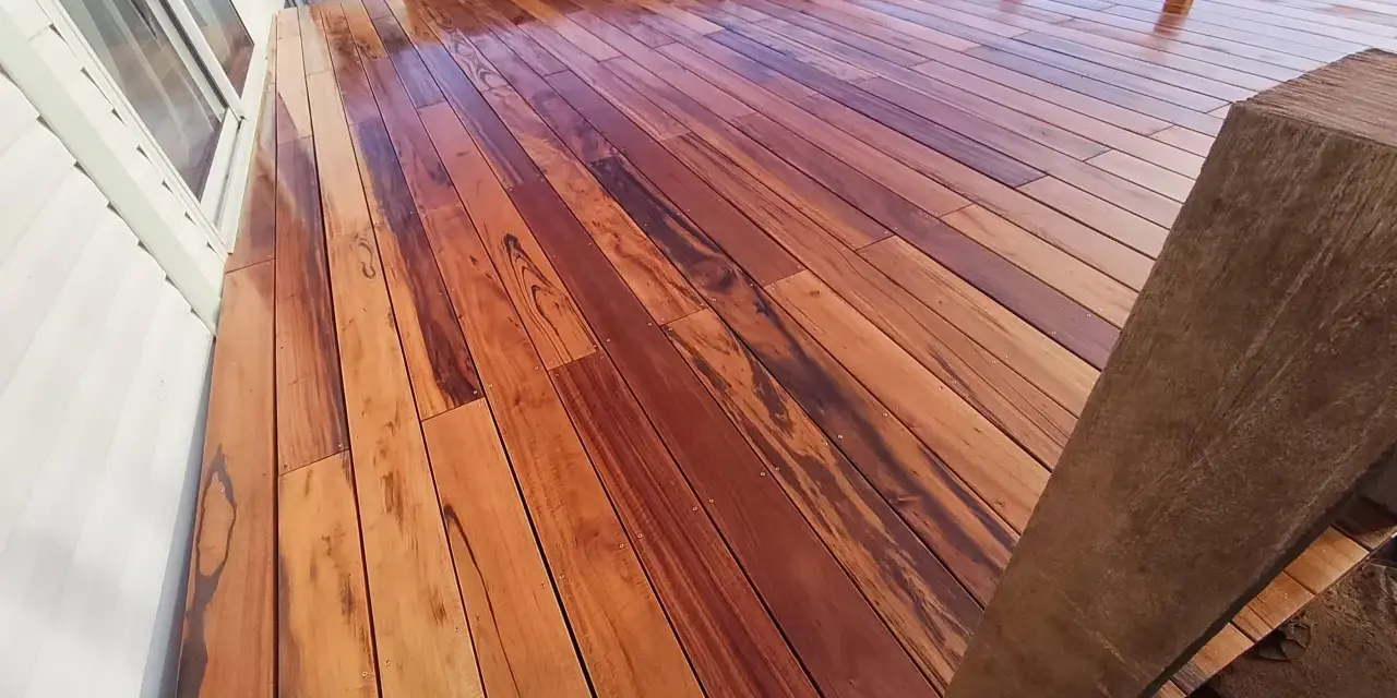 Planches de muiracatiara grisé, un bois exotique aux teintes chaudes et veinures marquées, formant une terrasse éclatante.