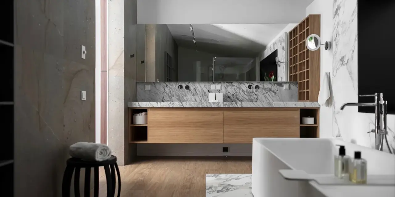 Salle de bain moderne avec meuble en bois clair, marbre et baignoire. Le bois est un excellent choix pour le meuble de salle de bain, alliant esthétique et durabilité.