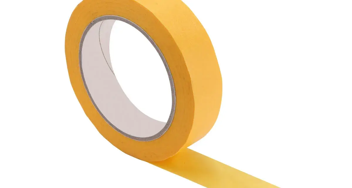 Rouleau de bande cache peinture jaune, prêt à être utilisé pour des découpes nettes. Savoir quand enlever bande cache peinture est essentiel pour un résultat parfait.