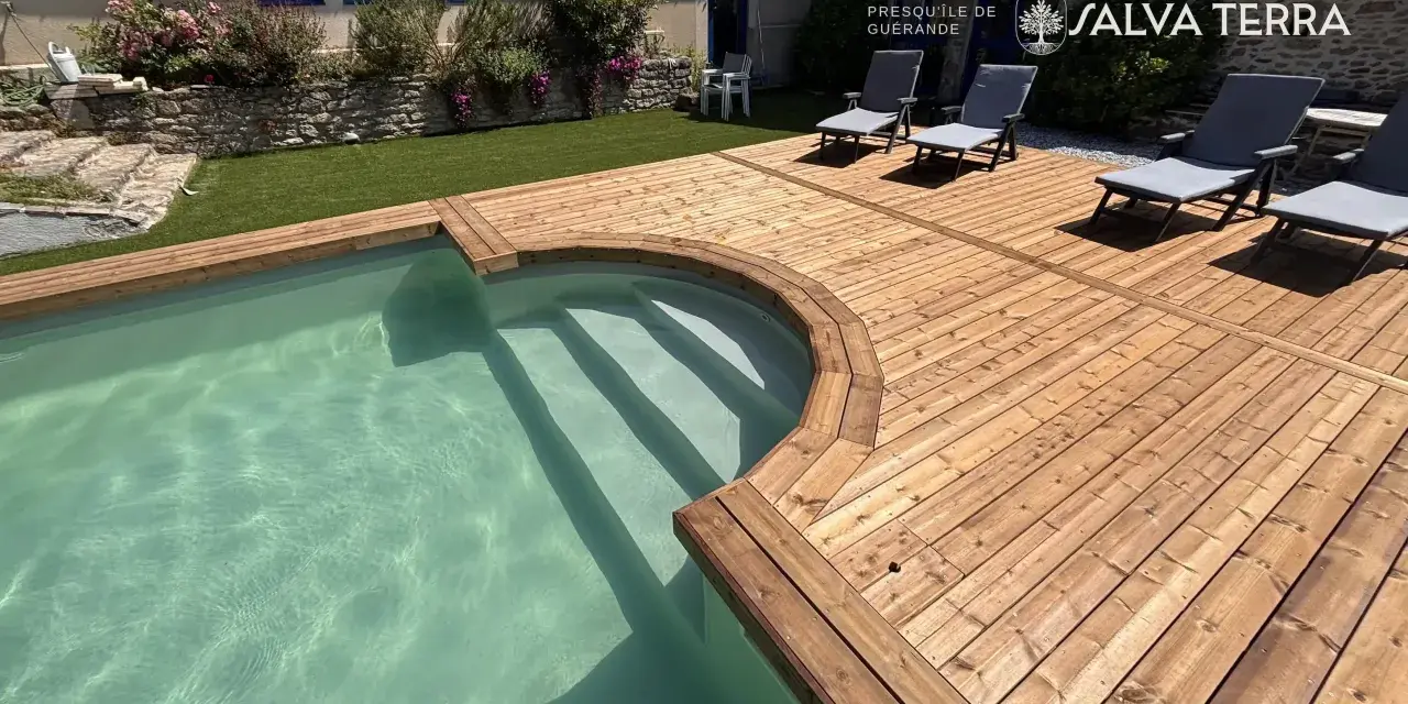 Terrasse en bois autour d'une piscine avec des chaises longues.