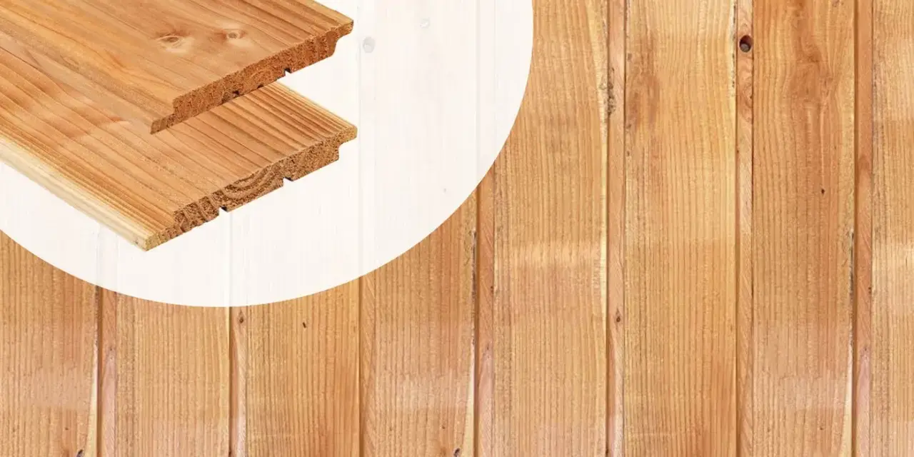 Planches de bois de mélèze ou douglas, avec leurs rainures et languettes, prêtes à être assemblées pour un projet de construction.