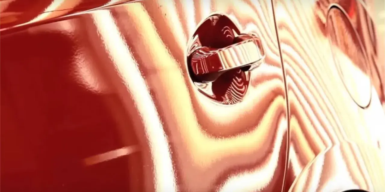 La peinture rouge d'une voiture présente des reflets ondulés, comme pour supprimer l'effet peau d'orange.