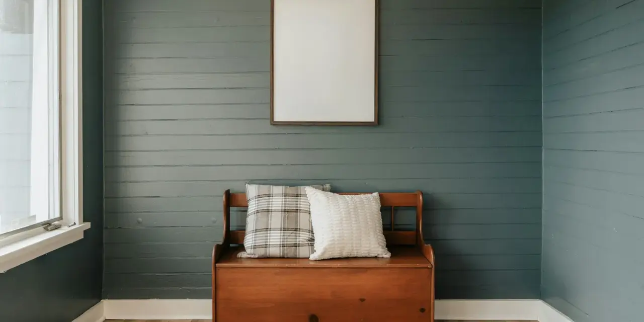 Avant/après : lambris repeint en bleu-gris, banc en bois avec coussins, cadre vide au mur.