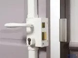 Détail du fonctionnement du barillet de serrure sur une porte blanche. Le mécanisme est visible avec sa poignée et son cylindre.