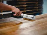 Application d'une finition sur un plateau en bois de manguier, assurant son entretien et sa beauté.