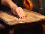 Main poncée pour enlever vernis bois. Le bicarbonate de soude peut aider à décaper.