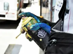 Main tenant une bombe de peinture jaune, un gant coloré montre comment enlever de la bombe de peinture.