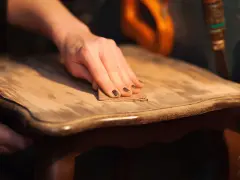 Main poncée pour enlever vernis bois. Le bicarbonate de soude peut aider à décaper.