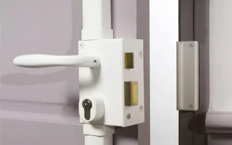 Détail du fonctionnement du barillet de serrure sur une porte blanche. Le mécanisme est visible avec sa poignée et son cylindre.