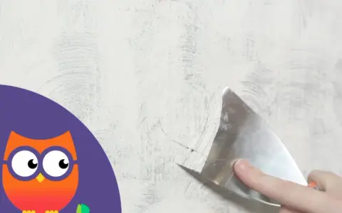 Maintenant, il faut enlever la peinture d'un mur avec une spatule. Un hibou curieux observe.
