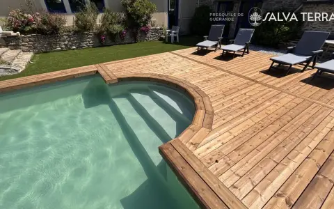 Terrasse en bois autour d'une piscine avec des chaises longues.