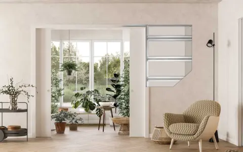 Vue d'un salon lumineux avec une grande baie vitrée donnant sur un jardin luxuriant. Un type de porte coulissante est visible, séparant l'espace intérieur de la véranda.