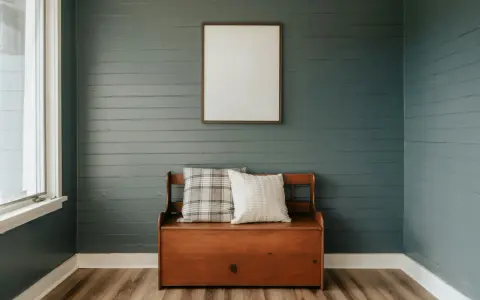 Avant/après : lambris repeint en bleu-gris, banc en bois avec coussins, cadre vide au mur.