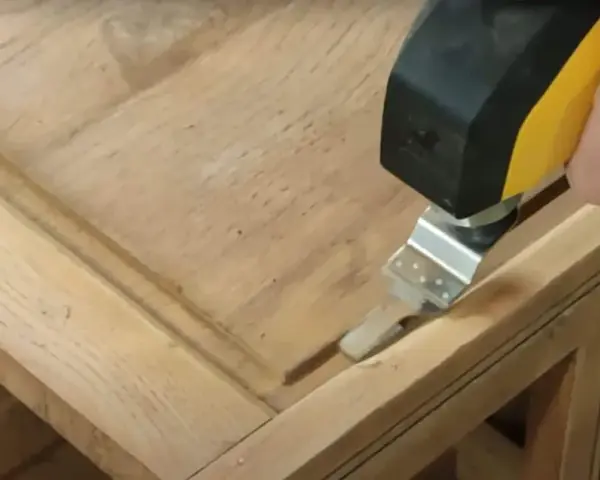 Outil oscillant utilisé pour comment poncer un meuble avec des moulures, atteignant les recoins difficiles.
