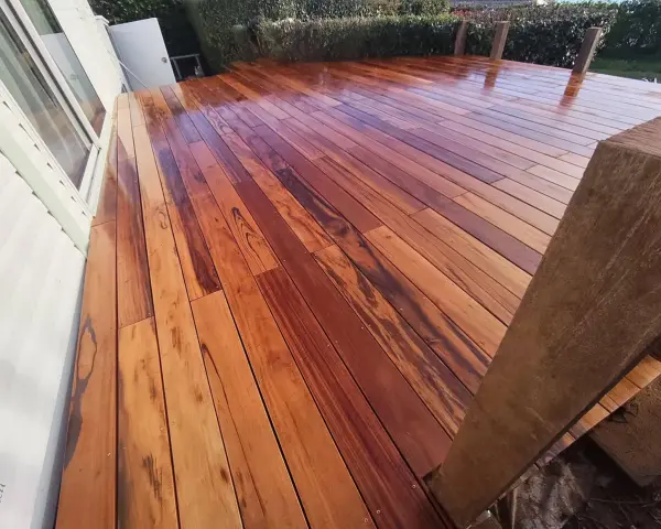 Planches de muiracatiara grisé, un bois exotique aux teintes chaudes et veinures marquées, formant une terrasse éclatante.