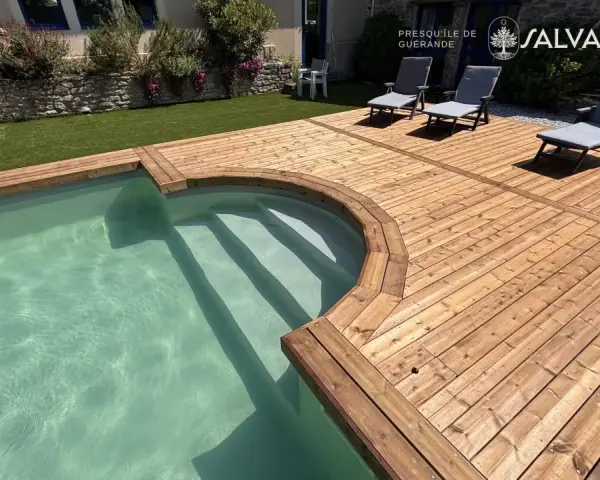 Terrasse en bois autour d'une piscine avec des chaises longues.