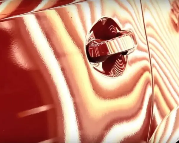 La peinture rouge d'une voiture présente des reflets ondulés, comme pour supprimer l'effet peau d'orange.