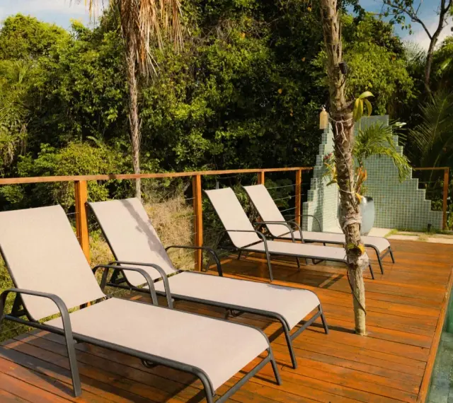 Chaises longues sur une terrasse en bois, parfait pour un entretien facile et profiter du soleil.