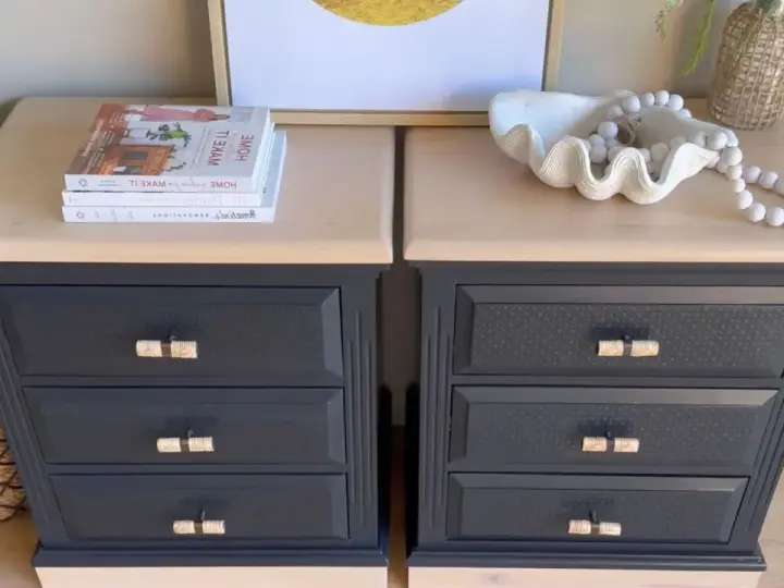 Deux commodes relookées noir et bois, avec des poignées en rotin, des livres et une coquille décorative.