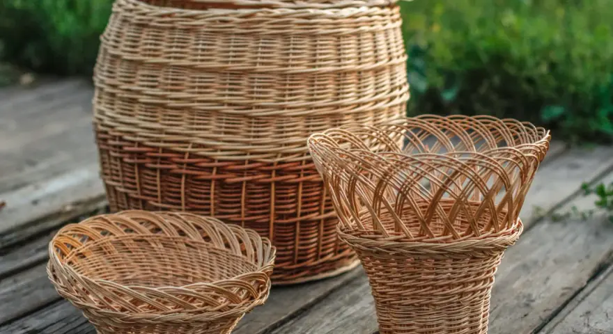 Trois paniers en rotin, dont un grand avec couvercle, prêts pour le nettoyage rotin avec vinaigre blanc.