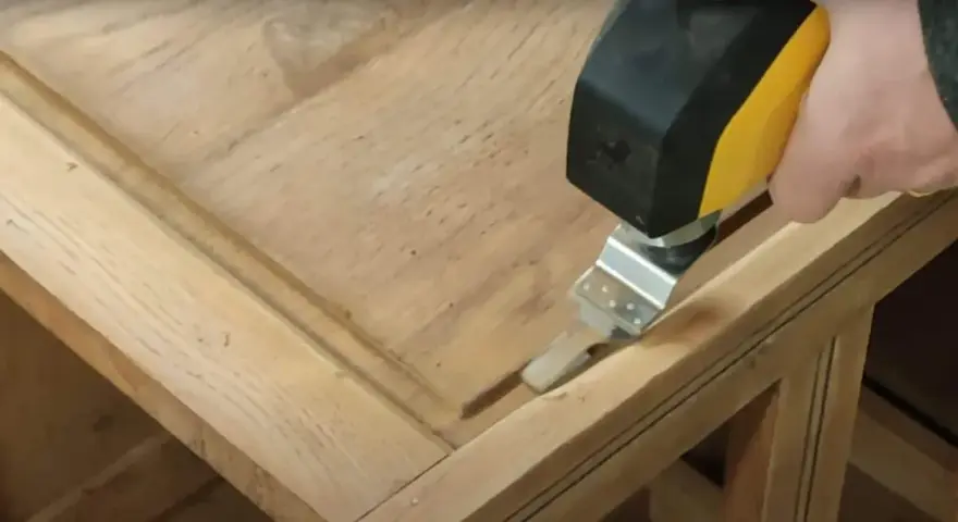 Outil oscillant utilisé pour comment poncer un meuble avec des moulures, atteignant les recoins difficiles.
