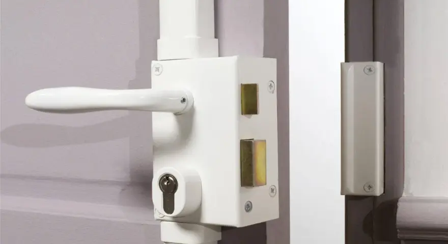Détail du fonctionnement du barillet de serrure sur une porte blanche. Le mécanisme est visible avec sa poignée et son cylindre.