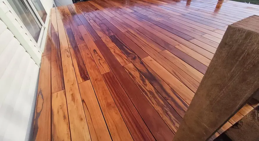 Planches de muiracatiara grisé, un bois exotique aux teintes chaudes et veinures marquées, formant une terrasse éclatante.
