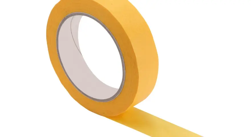 Rouleau de bande cache peinture jaune, prêt à être utilisé pour des découpes nettes. Savoir quand enlever bande cache peinture est essentiel pour un résultat parfait.
