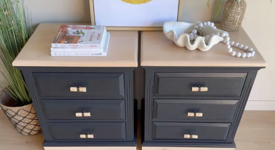 Deux commodes relookées noir et bois, avec des poignées en rotin, des livres et une coquille décorative.
