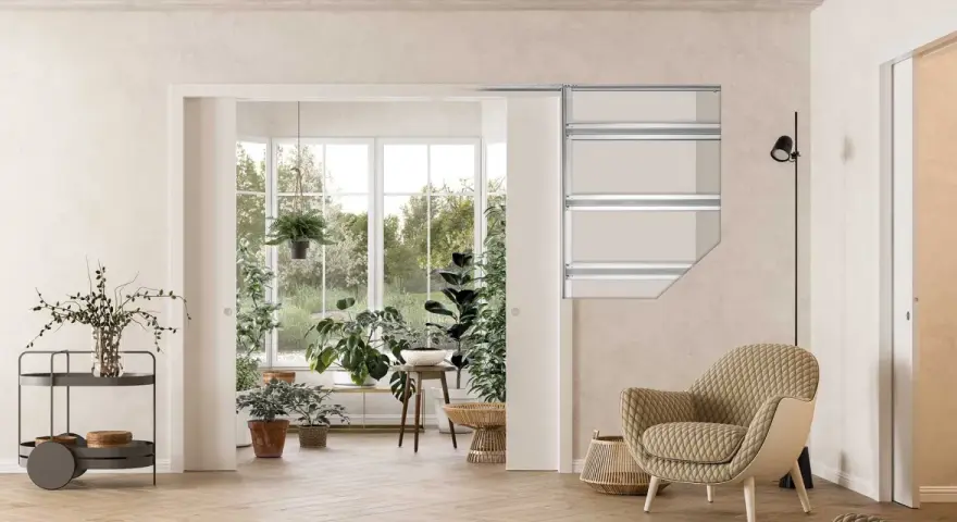Vue d'un salon lumineux avec une grande baie vitrée donnant sur un jardin luxuriant. Un type de porte coulissante est visible, séparant l'espace intérieur de la véranda.