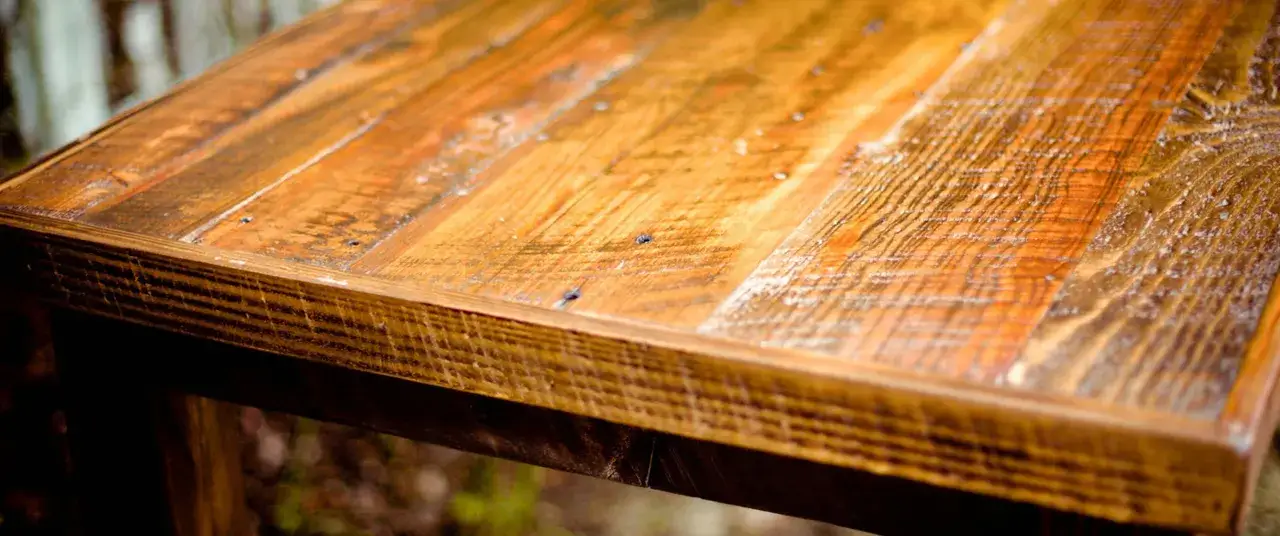 Surface d'une table en bois recycle, aux teintes chaudes et &agrave; la texture marqu&eacute;e.