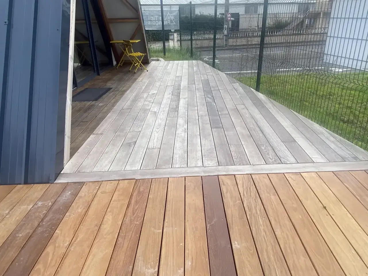 Terrasse en bois ipe vieilli, patine grise sur la partie sup&eacute;rieure, bois plus clair en premier plan.