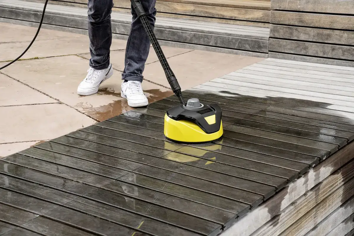 Nettoyage d'une terrasse en bois avec un Karcher, révélant la beauté naturelle du bois sous la saleté.