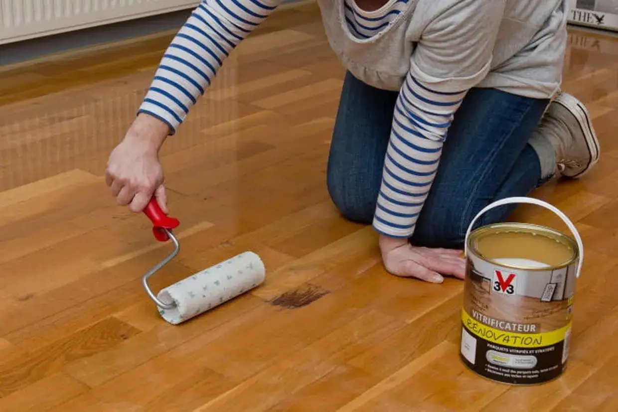Application de 2 ou 3 couches de vitrificateur sur un parquet en bois.